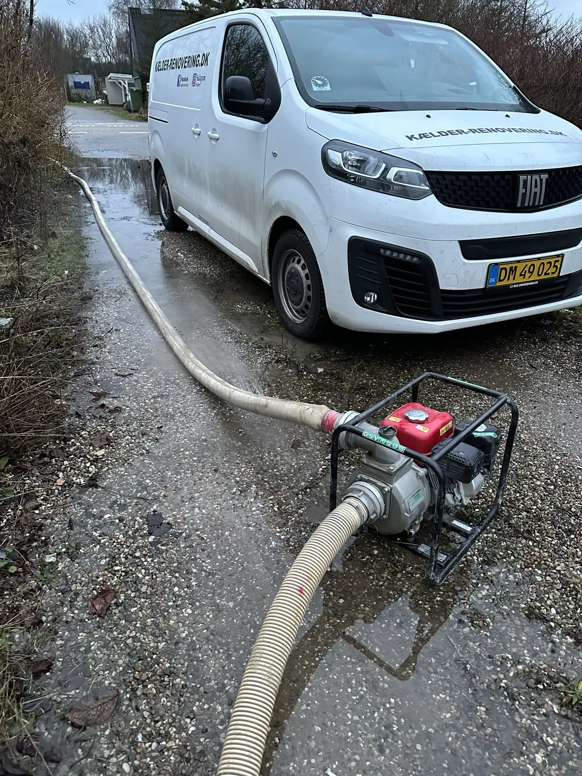 Motorpumpe og slanger under akut udpumpning af oversvømmet kælder