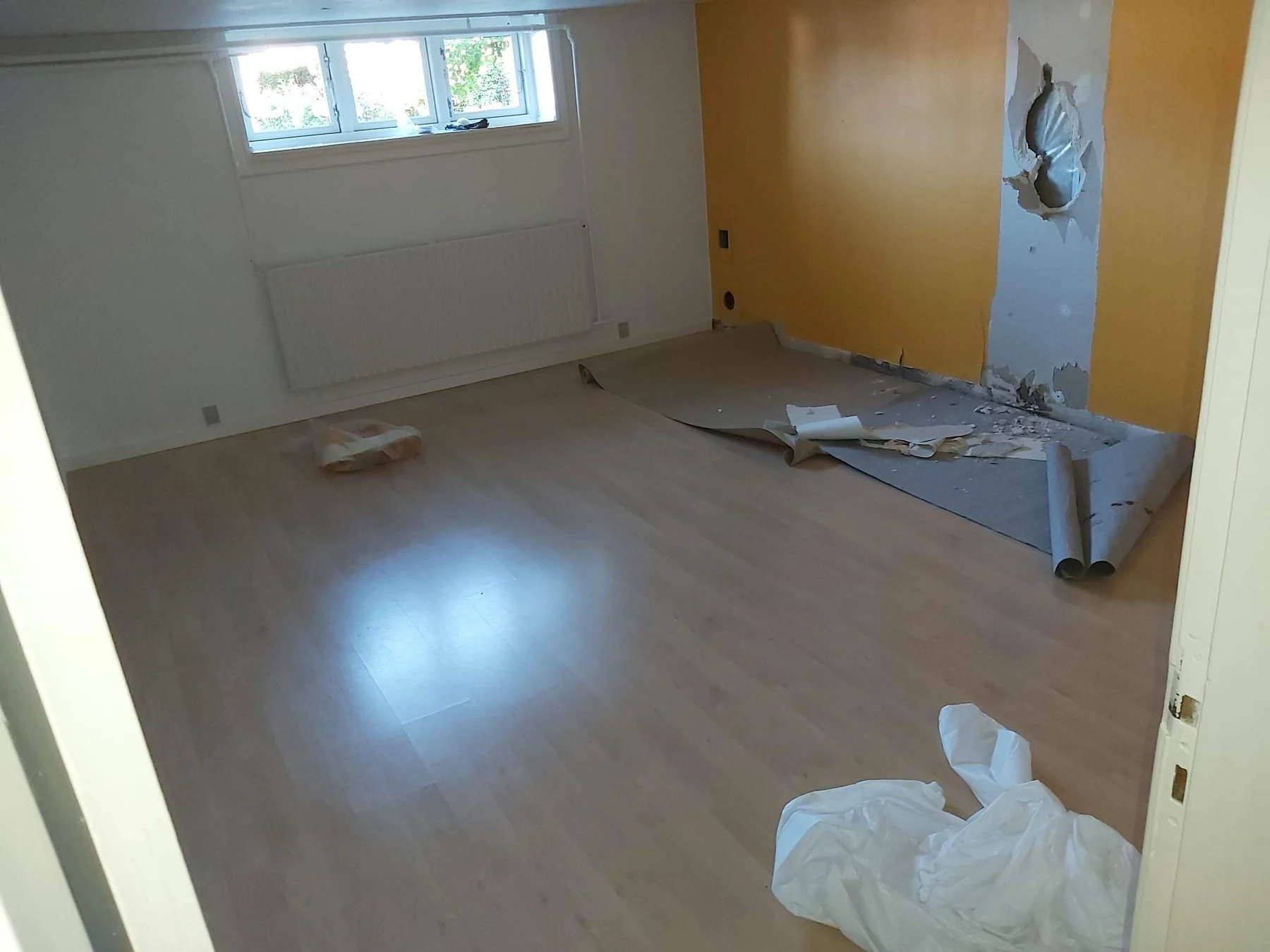 Kælderrum med forsatsvæg og klikgulv før renoveringen i Roskilde